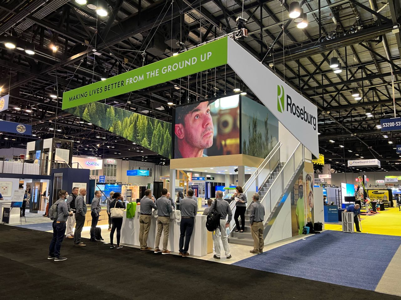 An exhibition booth with large-format display surfaces above and around the exhibit.