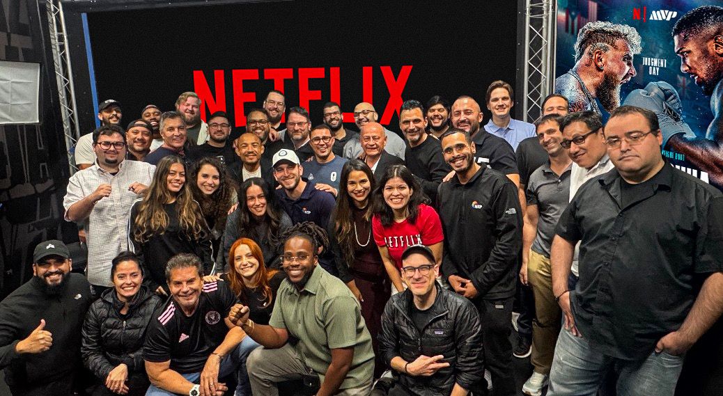 Production team photo in front of Netflix branding and a Jake vs. Joshua event display.