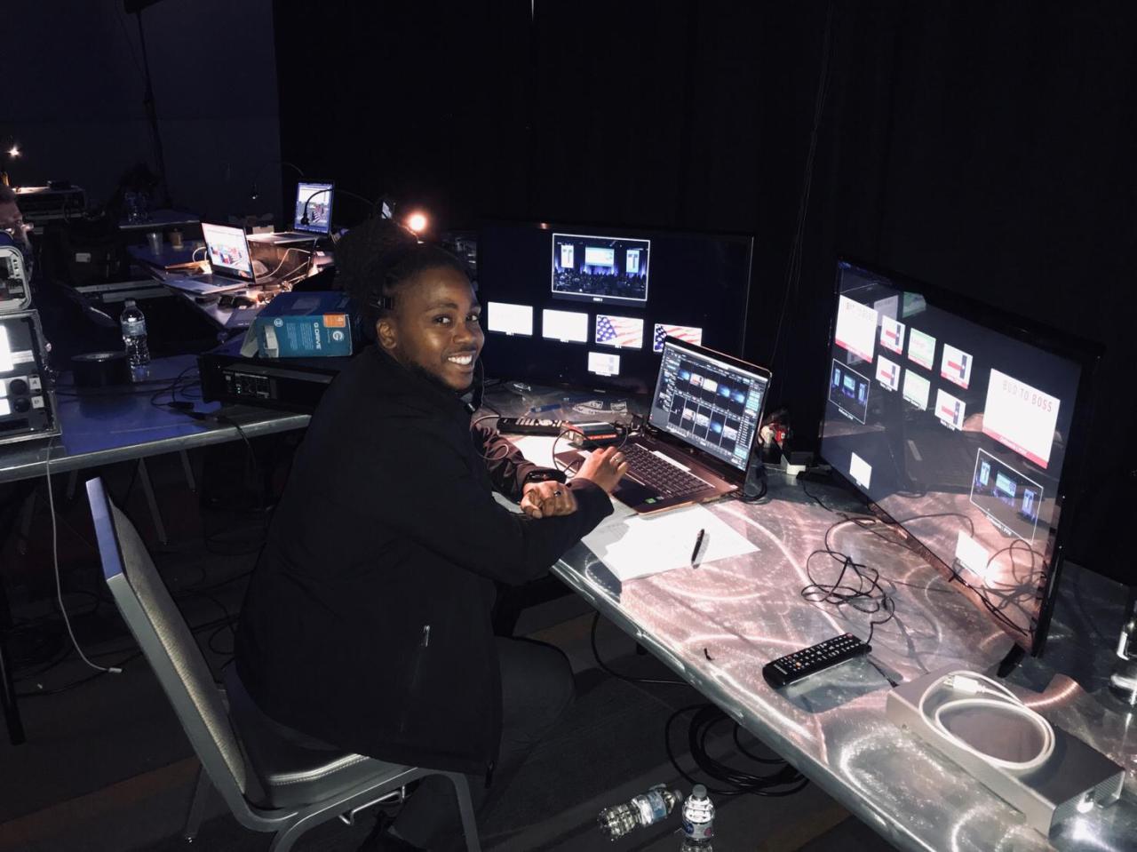 An operator at a playback workspace with a laptop and multiple video monitors.